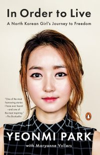 The book's title "In Order to Live," and subtitle, "A North Korean Girl's Journey to Freedom" appear over a headshot of author Yeonmi Park. Her name appears below. An excerpt from a book review appears to her left.
