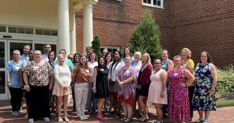 The 2023 class of the Global Education Teacher Leader Institute poses outside a brick building